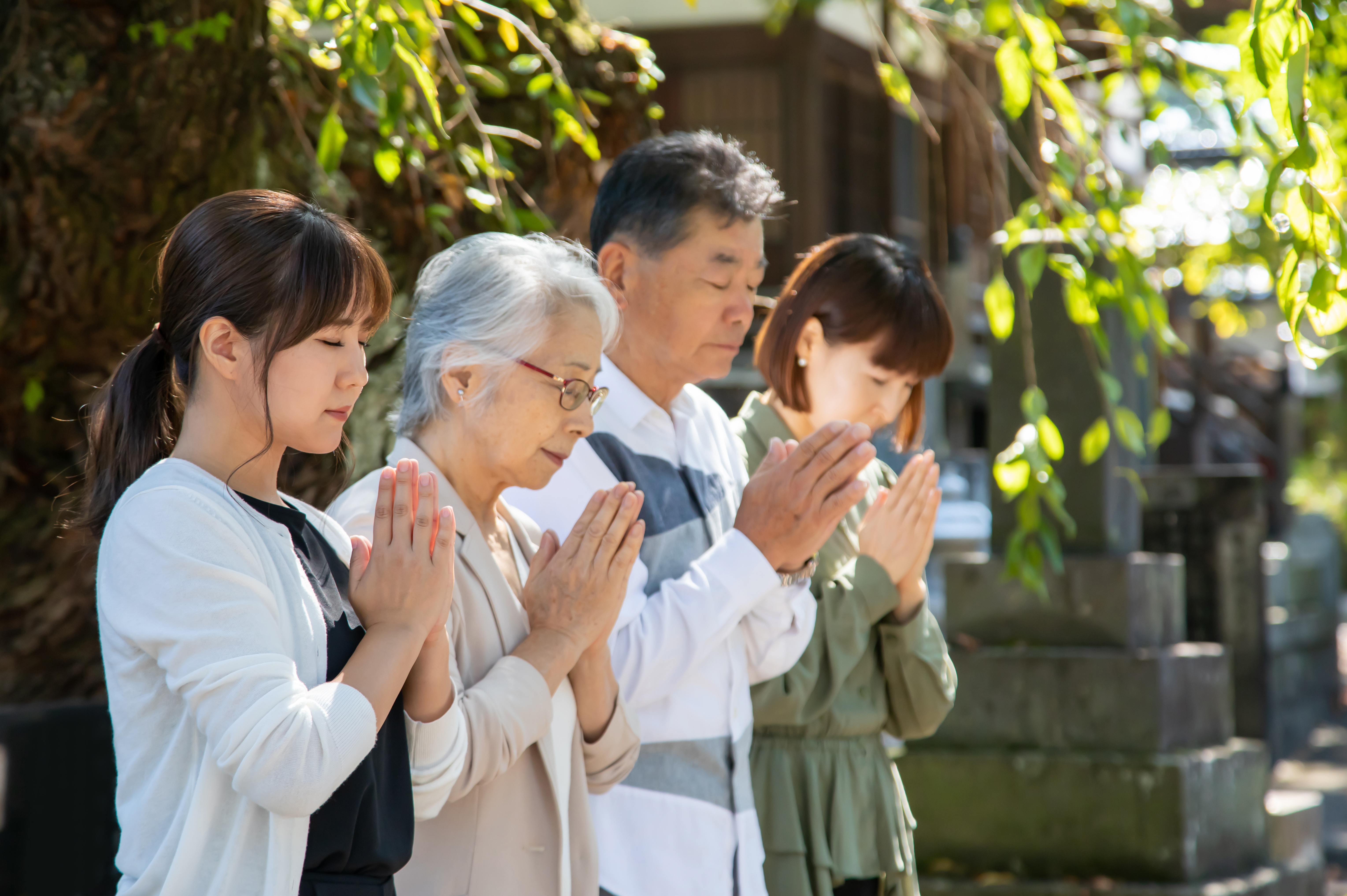 家族でお墓に手を合わせている写真